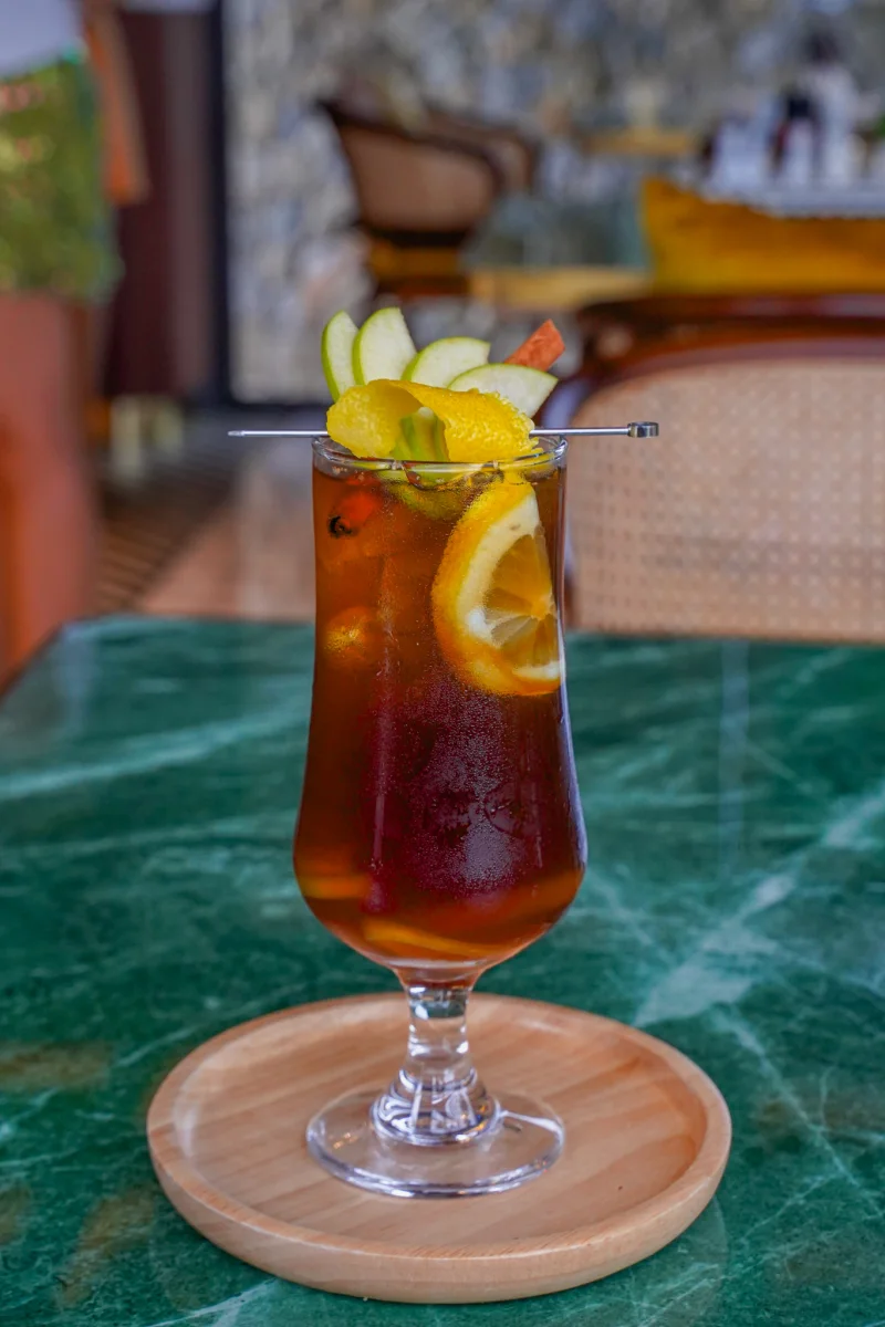 Iced tea with lemon and apple slices in a tall glass